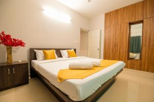 a bedroom with a large bed with yellow pillows at High Q Suites in Bangalore