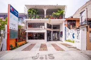 un edificio blanco con un balcón en el lateral. en Posada Jois, en Santa Cruz Huatulco