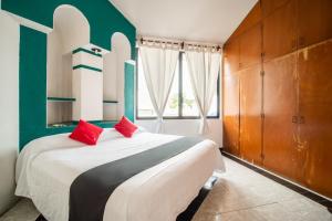 a bedroom with a large bed with red pillows at Posada Jois in Santa Cruz Huatulco