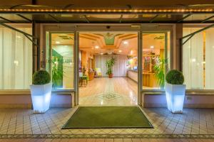 an entrance to a building with glass doors and plants at Hotel Palladio in Malcontenta