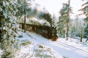 Er komt een trein over het spoor in de sneeuw. bij Pension Rosengarten in Sangerhausen