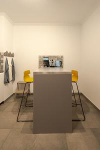 a counter with two yellow chairs in a room at Ocean Breeze in Caniço