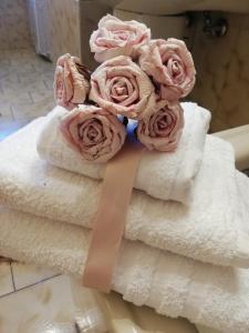 a bunch of towels with pink roses on them at Casa Francesca e Rooms in Santa Maria di Castellabate