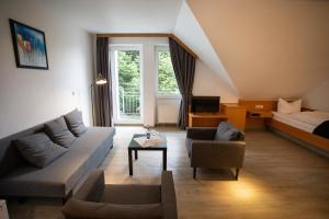 a living room with a couch and a bed at Das Loft Hotel Willingen in Willingen