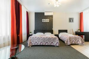 a hotel room with two beds and a glass table at Amber Hotel in Saint Petersburg