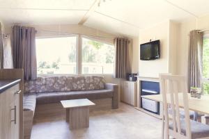 salon z kanapą i telewizorem w obiekcie Mobile Home 4p w mieście Zuna