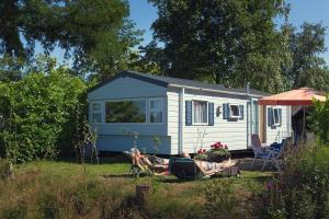 Przyczepa z ludźmi leżącymi na trawie przed nią. w obiekcie Mobile Home 4p w mieście Zuna