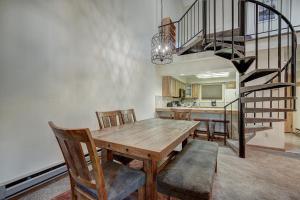 布雷肯里奇Atrium Eagle Condo: Downtown Breck, Spacious的一间带木桌和楼梯的用餐室
