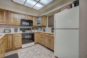 布雷肯里奇Atrium Eagle Condo: Downtown Breck, Spacious的配有木质橱柜和白色冰箱的厨房