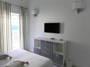 a bedroom with a bed and a tv on a wall at Elisir B&B in Anacapri