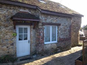 Ce cottage en pierre dispose d'une porte blanche et de 2 fenêtres. dans l'établissement la petite briarde, à Boissy-le-Châtel