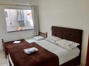 Un pat sau paturi într-o cameră la Residencial Sandini Garopaba