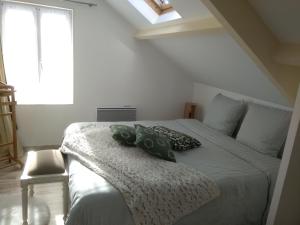 - une chambre avec un lit doté d'oreillers verts dans l'établissement la petite briarde, à Boissy-le-Châtel
