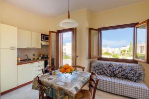 una cucina e una sala da pranzo con un tavolo e un divano di Residence Smeraldo a San Vito lo Capo Altre 20 foto