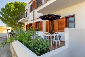 un tavolo e delle sedie su un balcone con un ombrellone di Residence Smeraldo a San Vito lo Capo