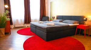 um quarto com uma cama grande num tapete vermelho em Highlight Suite Augarten em Viena