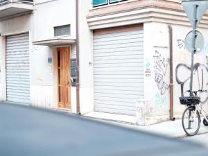 ein Fahrrad, das vor einem Gebäude mit Graffiti geparkt ist in der Unterkunft Oasi 83 in San Benedetto del Tronto