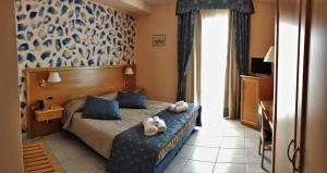 ein Hotelzimmer mit einem Bett mit Handtüchern darauf in der Unterkunft Hotel Bristol in Enna