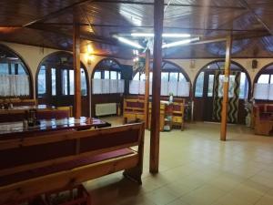 a restaurant with a wooden ceiling and tables and benches at Bar & Guests room ELA in Dolen Bliznak +9 photos