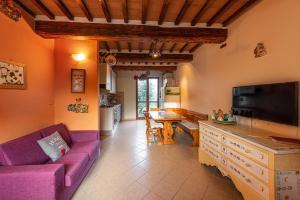 - un salon avec un canapé violet et une table dans l'établissement L'Olivo Gina, Minnie's Cottage, à Montalcino