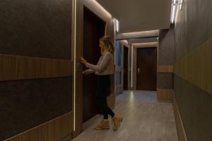 a woman standing in a hallway with a door open at Hotel Diego de Velazquez in Santiago