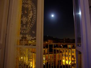 a window with a view of a city at night at L'Una di Notte in Salerno