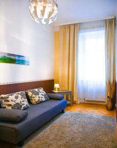 sala de estar con sofá y ventana grande en Highlight Suite Augarten, en Viena