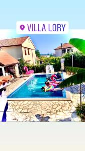 a group of people laying in a swimming pool at Villa Lory Krk in Krk