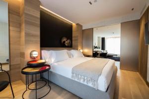 a bedroom with a large white bed and a desk at Zenit Convento San Martin in Donostia-San Sebastián