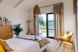 a bedroom with a bed and a large window at Quinta das Alfazemas in Ericeira