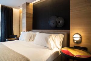 a bedroom with a white bed with a black wall at Zenit Convento San Martin in Donostia-San Sebastián