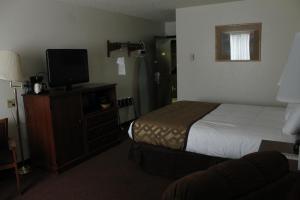 a hotel room with a bed and a flat screen tv at Lone Tree Inn in Sidney