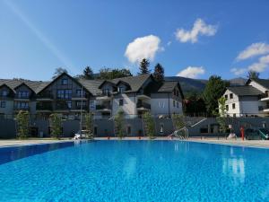 a large swimming pool with a blue sky at Artus Resort in Karpacz