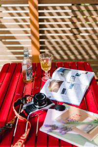 a red table with a book and a glass of wine at Quinta das Alfazemas in Ericeira