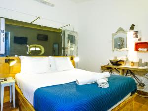 una camera da letto con un grande letto con asciugamani di Lovin Book Guesthouse a Óbidos