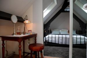 1 dormitorio con cama y mesa con espejo en Amadeus Restaurant & Boutique Hotel, en Well