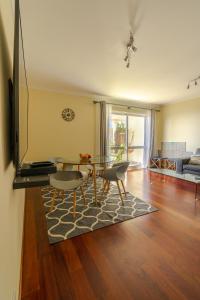 a living room with a table and chairs and a couch at Ocean Breeze in Caniço