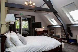 una camera da letto con un grande letto bianco e finestre di Amadeus Restaurant & Boutique Hotel a Well