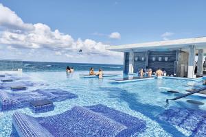 een groep mensen in een zwembad bij de oceaan bij Riu Palace Paradise Island - Adults Only - All Inclusive in Nassau