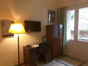 a room with a desk and a lamp and a window at Rothschild Tel-Aviv Studio in Tel Aviv