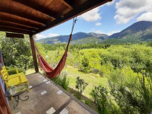 a porch with a hammock and a view of the mountains at Cabañas Las Nativas in Lago Puelo