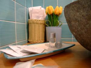 a tray with a vase with yellow tulips in a bathroom at L'Una di Notte in Salerno
