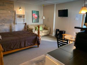 um quarto de hotel com uma cama e uma sala de estar em Le Loft Riverstone em Saint Pierre de Broughton