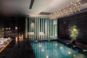 a hotel room with a swimming pool and a bedroom at Lure Hotel & Spa - Adults Only in Mellieħa