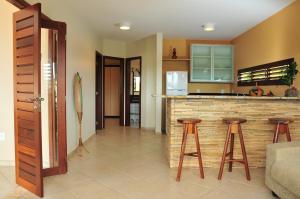 a kitchen with a bar with two stools in it at Pipa Park in Pipa