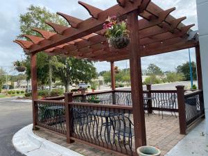 a wooden pergola with tables and chairs on a patio at Baymont by Wyndham Wilmington in Wilmington