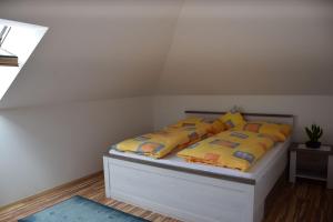 uma cama com almofadas amarelas num quarto em EKO-Hof em Mitterlabill