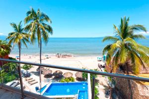 Vallarta Shores Beach Hotel في بويرتو فايارتا: اطلالة على شاطئ به نخل والمحيط