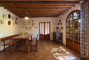 una sala da pranzo con tavolo in legno e TV di Hort Den Gelos Campanet Mallorca a Crestatx