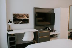 a bedroom with a white desk and a tv at Hotel Indigo - St. Louis - Downtown, an IHG Hotel in Saint Louis